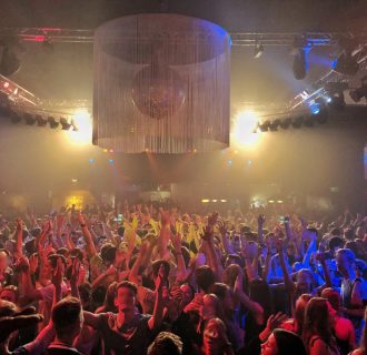 Party mit DJ René Pera. Man sieht die volle Tanzfläche der Live Music Hall/Köln bei einem Event. Alle reissen die Arme in die Luft.